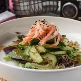 Cucumber salad topped with toasted sesame seeds.