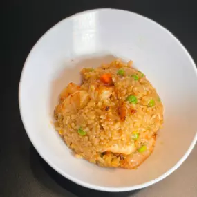 White Rice stir-fried with garlic butter, soy sauce, shrimp, egg, peas, carrots and teriyaki sauce.