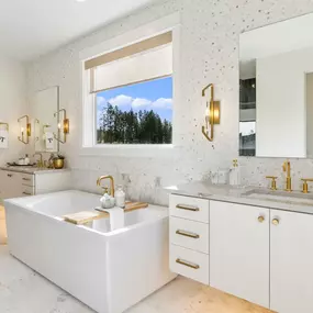 Elegant primary bathroom in the Cirrus with separate vanities and soaking tub