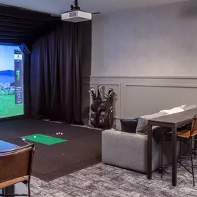 A room with a golf simulator screen