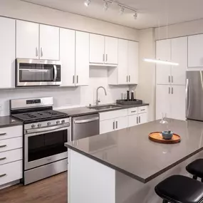A modern kitchen with white cabinets and stainless steel appliances