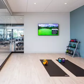 Gym with exercise equipment and a TV screen