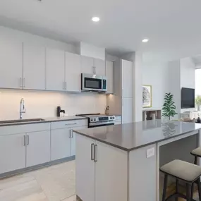 The kitchen at The Holston features an open layout that flows into the living room with balcony access.