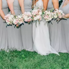 Bride's maids posing in white dresses holding bouquets designed by Christina Price, a wedding florist for Hagerstown.