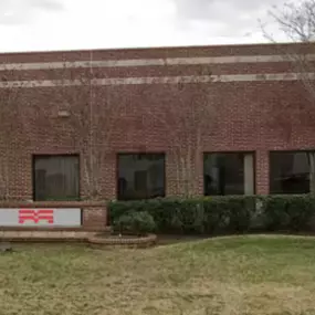 Exterior of the Methods Machine Tools facility in Houston, Texas, featuring a red brick facade and well-maintained landscaping.