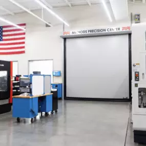 Inside the Methods Precision Center, this Houston, TX facility showcases advanced CNC machines in a clean, modern workspace beneath the American flag.