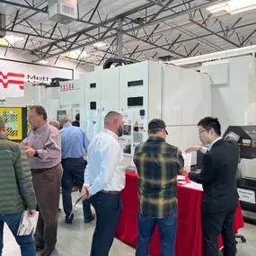 Guests networking during the grand opening event at Methods Machine Tools' Corona location, discussing CNC machining innovations.