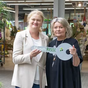 Frau Claudia Röttger überreicht symbolischen Schlüssel zur Eröffnung des Blumen-Risse Gartencenters in Bergkamen an Frau Tina Risse-Stock