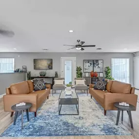 A living room with a brick wall and a variety of seating options.