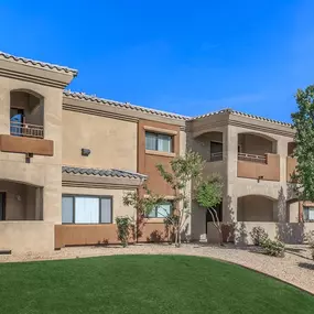 A townhome with a green lawn in front.