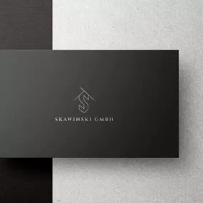Visitenkarte der SKAWINSKI GmbH mit Logo und Firmenname auf schwarz-weißem Hintergrund