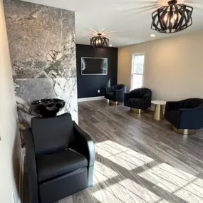 Garage transformation into a sleek, fully functional hair salon with custom finishes, luxury vinyl flooring, and a modern lounge-style seating area.