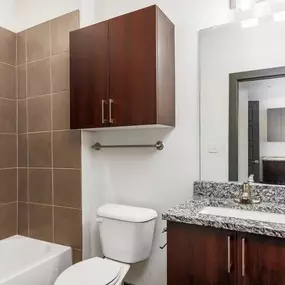 A bathroom with a toilet, sink, and mirror