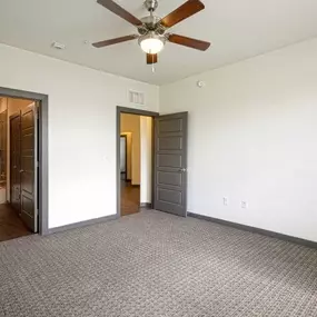 An empty bedroom with a ceiling fan