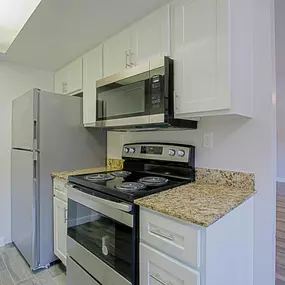 A kitchen with a granite countertop and stainless steel appliances.