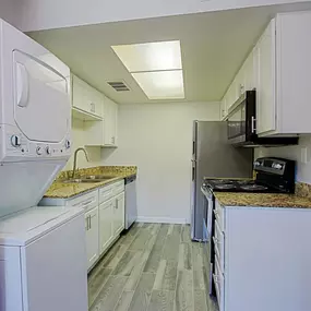 A kitchen with white appliances and cabinets.