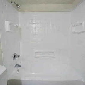 A white bathroom with a tub, toilet and sink.