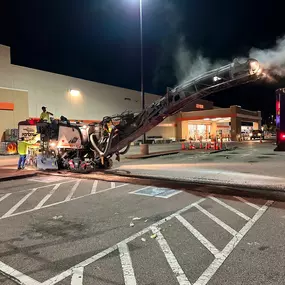 Nighttime milling project at a commercial property, with lights and equipment in use