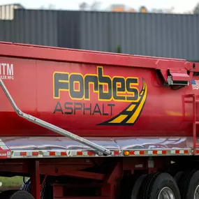 Side view of a red Forbes Asphalt dump truck featuring the company logo
