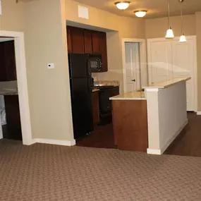 A kitchen with a black refrigerator and white cabinets