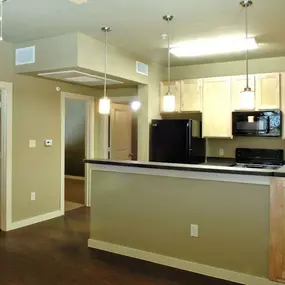A kitchen with a black refrigerator and microwave.