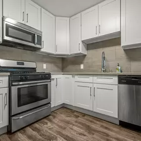 A kitchen with wooden cabinets and black appliances.