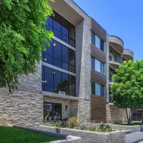 A modern building with a stone facade and a glass entrance.