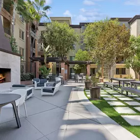 A patio with a fireplace and chairs.