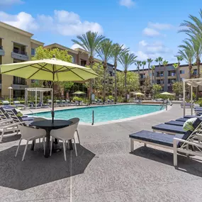 A poolside area with sun loungers and umbrellas.