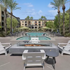 A pool surrounded by palm trees and chairs.