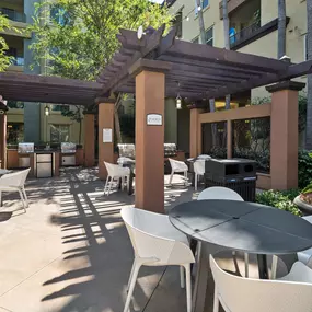 A patio with tables and chairs under a pergola.