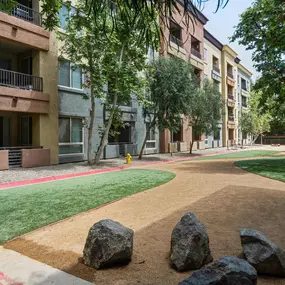 A large rock sits in the middle of a dirt path.