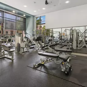 A gym with a variety of equipment including weights and machines.