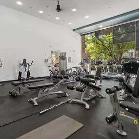 A gym with a variety of equipment including weights and machines.