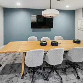 A conference room with a long table and chairs.