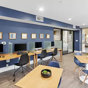 A room with blue walls and wooden tables with chairs.