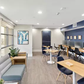 A room with a blue wall and a white ceiling with a painting on the wall.