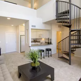A living room with a spiral staircase and a coffee table.