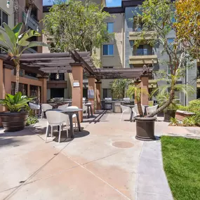 A patio area with a table and chairs surrounded by plants and trees.