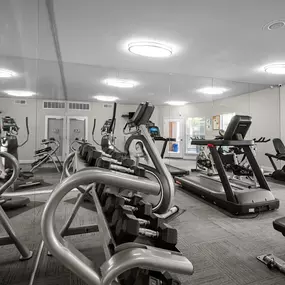 A gym with a variety of exercise equipment including treadmills, stationary bikes, and weight machines. at Preston Bend, Dallas