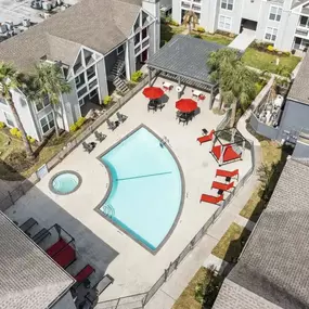 Aerial view of a swimming pool and patio with umbrellas