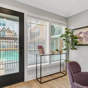 A living room with two chairs and a door to a balcony