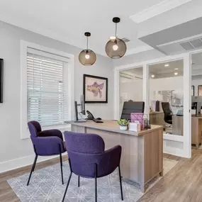 A living room with purple chairs and a reception desk