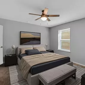 A bedroom with a bed and a ceiling fan