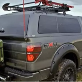 A truck with a rack on top, featuring a tonneau cover for added cargo protection and versatility.