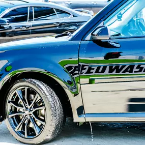 Close‑up of a freshly washed vehicle parked in front of Silverlake Speedwash’s green vacuum stations—illustrating the mirror‑like shine delivered when pairing the express tunnel and post‑wash vacuum with care.