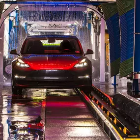 A sleek Tesla drives through Silverlake Speedwash’s cutting-edge tunnel system—highlighting their ability to handle luxury and electric vehicles with speed, care, and modern cleaning tech.