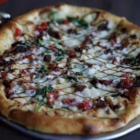 Crab Dip Pizza from Water Street Grille in Yorktown, VA — a creamy, seafood-inspired specialty topped with warm crab dip, spinach, bacon, and roasted red peppers.