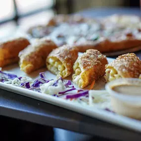 Close-up of golden-fried mac and cheese egg rolls, a Water Street Grille fan favorite on the appetizer menu.