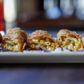 Close-up of golden-fried mac and cheese egg rolls, a Water Street Grille fan favorite on the appetizer menu.